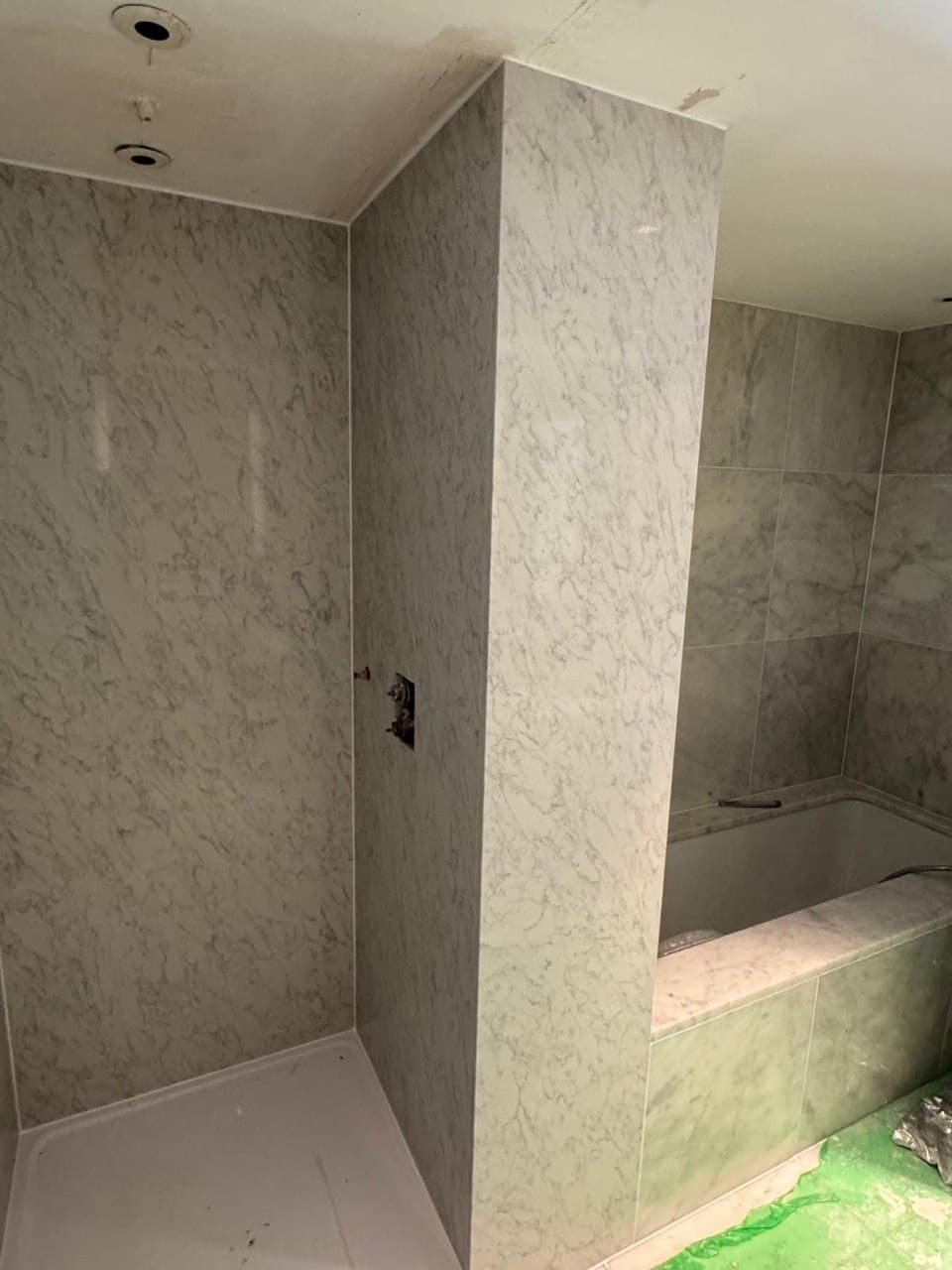 Large-format marble slabs being installed in the principal bathroom